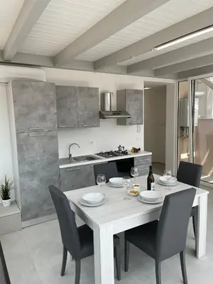 a kitchen with a white table and chairs in a room at La Terrazza sul Golfo in Castellammare del Golfo