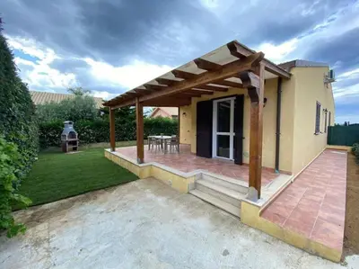 a pavilion with a table and chairs on a patio at Villa indipendente le coccinelle beach mare piscina a 250 mt dal mare con servizio di piscina a 400 mt 12 k da Cefalu in Campofelice di Roccella