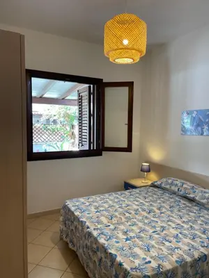 a bedroom with a bed and a window at Belmare trilocale a piano terra indipendente in San Vito lo Capo