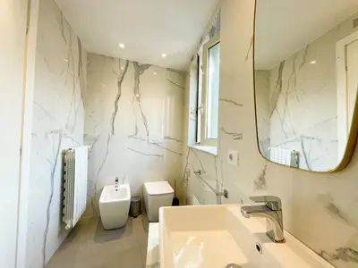 a bathroom with a sink and a toilet and a mirror at Dimora San Gregorio Luxury Rooms in Palermo