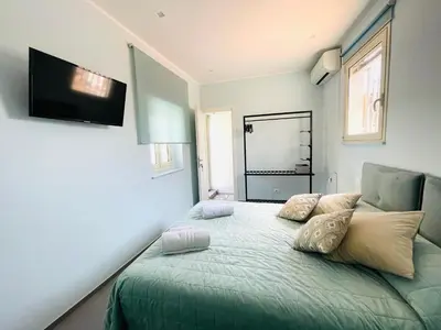 a bedroom with a green bed and a flat screen tv at Dimora San Gregorio Luxury Rooms in Palermo