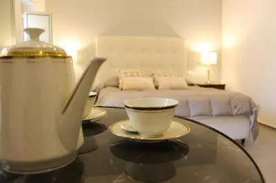 a table with a cup of coffee and a bed at Dimora San Gregorio Luxury Rooms in Palermo