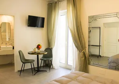 a bedroom with a table and chairs and a bed at Dimora San Gregorio Luxury Rooms in Palermo