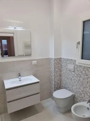 a bathroom with a sink and a toilet and a mirror at Lovely apartment in Castellammare del Golfo in Castellammare del Golfo
