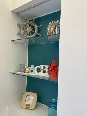 a shelf with a wheel and a clock on it at Casa Chiara in Isola delle Femmine