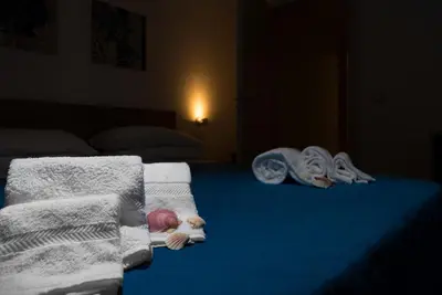 a bed with towels and blankets on top of it at I Tre Golfi - Via Salvatore Quasimodo in San Vito lo Capo