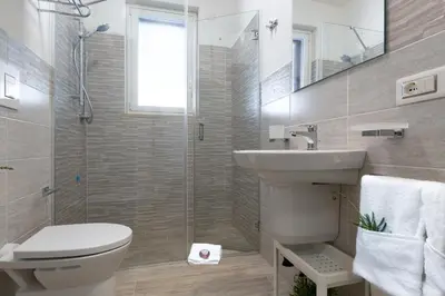 a bathroom with a toilet and a sink and a shower at I Tre Golfi - Via Salvatore Quasimodo in San Vito lo Capo