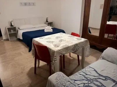 a bedroom with a bed and a table and chairs at Casa Carina in Centro in Palermo
