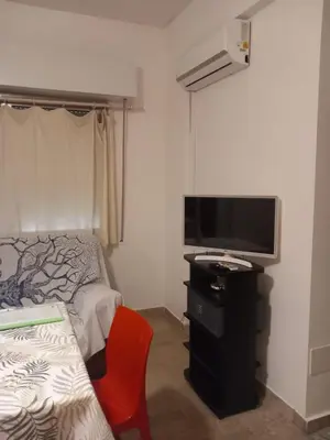a bedroom with a bed and a tv and a red chair at Casa Carina in Centro in Palermo