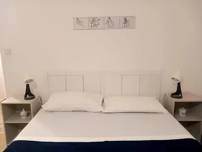 a bedroom with a white bed with two lamps at Casa Carina in Centro in Palermo