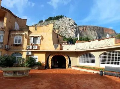 a building with a mountain in the background at Raggio di sole in Ashur in Palermo