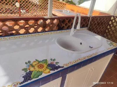 a bathroom sink with a flower painted on the counter at Raggio di sole in Ashur in Palermo