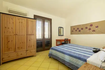 a bedroom with a bed and a sliding glass door at Casa Vacanza Azzurra 4 in San Vito lo Capo