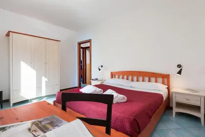 a bedroom with two beds and a table and a desk at Casa Vacanza Azzurra 4 in San Vito lo Capo