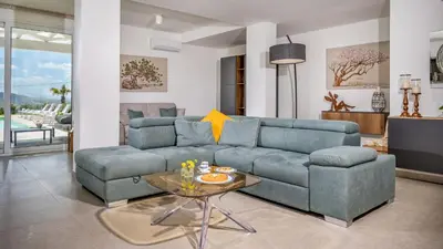 a living room with a blue couch and a table at DAMA DEI VENTI 6&2, Emma Villas in Castellammare del Golfo