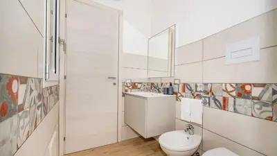 a bathroom with a toilet and a sink at DAMA DEI VENTI 6&2, Emma Villas in Castellammare del Golfo