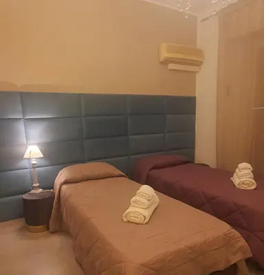 a bedroom with two beds with towels on them at Rosa Apartament in Palermo