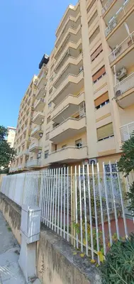 a white fence in front of a tall building at Rosa Apartament in Palermo
