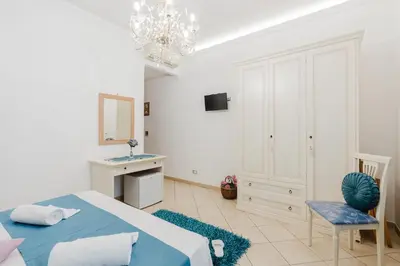 a bedroom with a bed and a sink and a mirror at B&B Le Ortensie in San Vito lo Capo