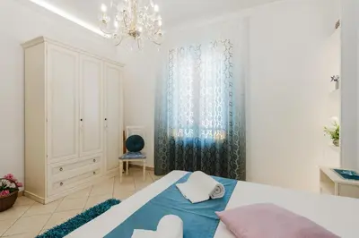 a bedroom with a bed and a chandelier at B&B Le Ortensie in San Vito lo Capo