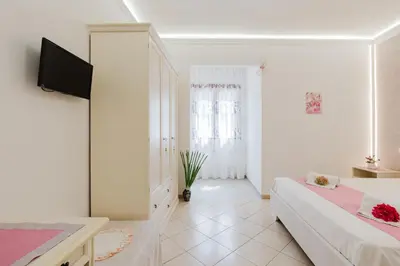 a white room with a bed and a tv at B&B Le Ortensie in San Vito lo Capo