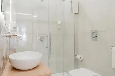 a white bathroom with a sink and a shower at B&B Le Ortensie in San Vito lo Capo