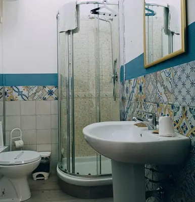 a bedroom with a green bed and a bathroom at Teatro del Sole Cavour in Palermo