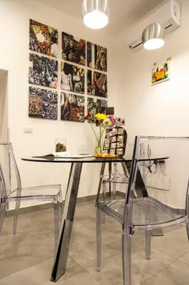 a dining room with a glass table and chairs at Sant’Agostino Boutique Rooms in Palermo