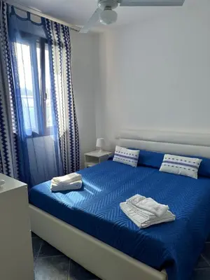 a bedroom with a blue bed with two towels on it at Villa con piscina privata riscaldata ad uso esclusivo vicino Cefalù in Lascari