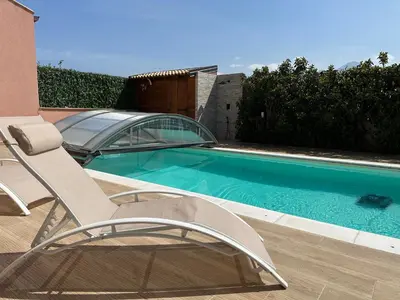 a chair sitting next to a swimming pool at Villa con piscina privata riscaldata ad uso esclusivo vicino Cefalù in Lascari