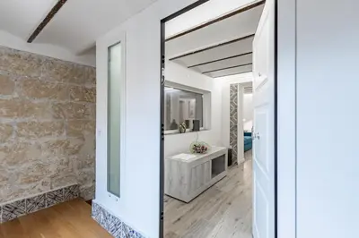 a bathroom with a stone wall and a mirror at GuestHost - Palermo Modern and Central Apartment x6 in Palermo