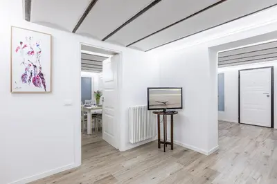 a room with white walls and a television on a table at GuestHost - Palermo Modern and Central Apartment x6 in Palermo