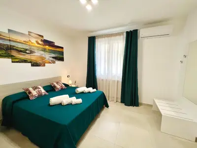 a bedroom with a green bed with towels on it at Meravigghia in Terrasini
