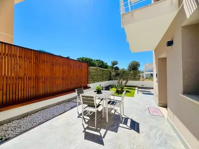 a patio with a table and chairs and a fence at Meravigghia in Terrasini
