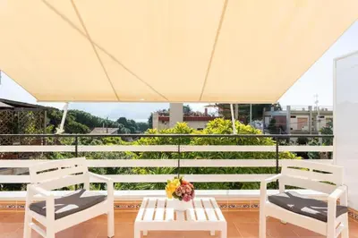 a patio with white chairs and a table with flowers on it at Casa Mare me' in Mondello