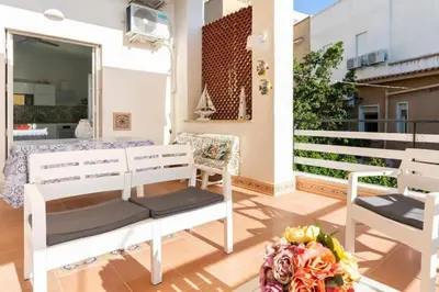a porch with two benches and a vase of flowers at Casa Mare me' in Mondello