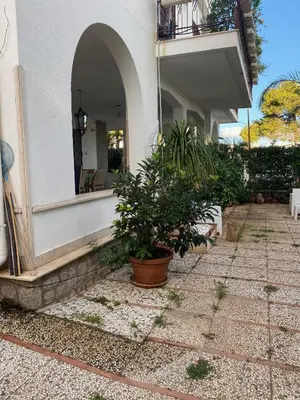 a house with potted plants on a patio at Holiday & House - Imparato Carini Costa Verde - Appartamento con giardino privato - porzione di Villa residenziale a pochi passi dal mare in Carini