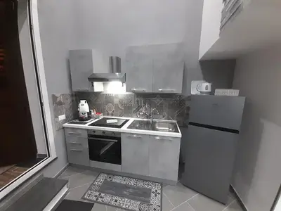 a small kitchen with a stove and a refrigerator at House Under Arch in Palermo