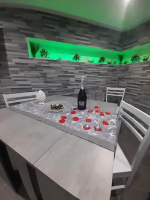 a table with a bottle of wine and glasses on it at House Under Arch in Palermo