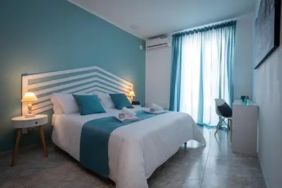 a bedroom with a large white bed with blue pillows at A casa di Cilu - Centro Storico in Palermo
