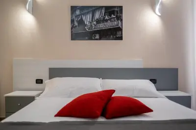 a bed with two red pillows on top of it at I Quattru Vuci Rooms in Palermo
