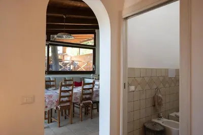 a kitchen and dining room with a table and a window at Villa Premiere immersa nel verde a Castelluzzo in Castelluzzo