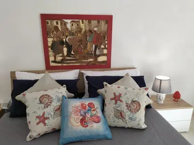 a bedroom with a bed with pillows and a painting at InCentro Palermo in Palermo