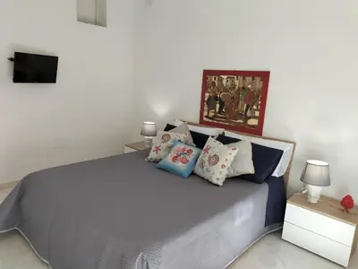 a bedroom with a bed with pillows and a tv at InCentro Palermo in Palermo