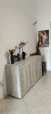 a wooden cabinet with flowers on it in a room at InCentro Palermo in Palermo