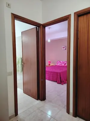 a bedroom with a pink bed in a room at DernaFlat 15 Climatizzata in Castellammare del Golfo