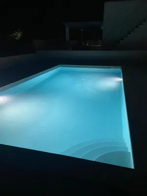 a swimming pool lit up at night at Villa Portofino - Private pool in Campofelice di Roccella
