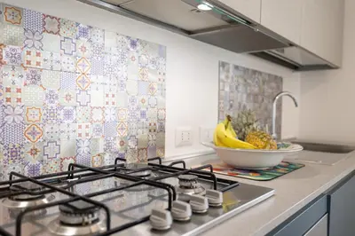 a kitchen with a stove and a bowl of fruit at Villa Portofino - Private pool in Campofelice di Roccella