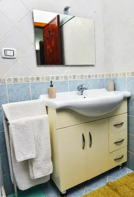 a bathroom with a sink and a mirror at Amaryllis Apartments in Bagheria