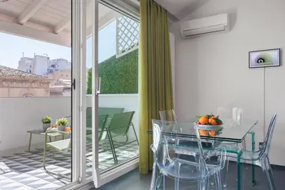 a dining room with a glass table and chairs at Archimedes luxury apartment with terrace in Palermo
